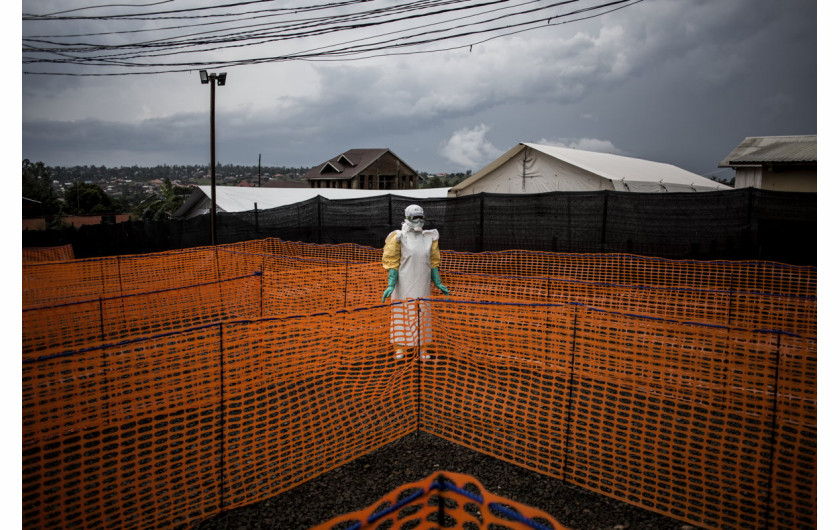 fot. John Wessels, Agence France-Presse, Fighting Ebola and Conflic, 3. miejsce w kategorii General News.


Beni w północno wschodnim Kongo targane jest konfliktem od 25 lat. W 2018 roku dotknięte zostało także epidemią Eboli. Szacuje się, że w regionie aktywnych jest około 100 uzbrojonych grup, które walczą z siłami rządowymi, misją stabilizacyjną ONZ siłami ADF i innymi rebeliami. W czasie epidemii walki przybrały na sile, a opanowanie jej w warunkach bojowych było praktycznie niemożliwe. W efekcie zanotowano niemal 700 zachorowań i ponad 460 zgonów. Była to druga co do wielkości epidemia w historii.